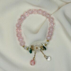 Light pink beaded bracelet with a white flower charm!